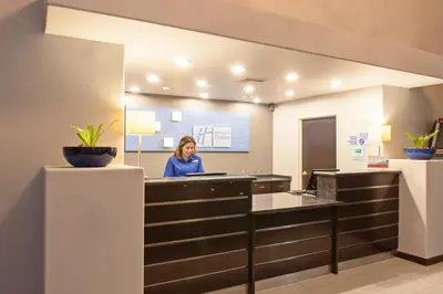 a woman sitting at a reception desk in a lobby at Holiday Inn Express Temecula by IHG in Temecula