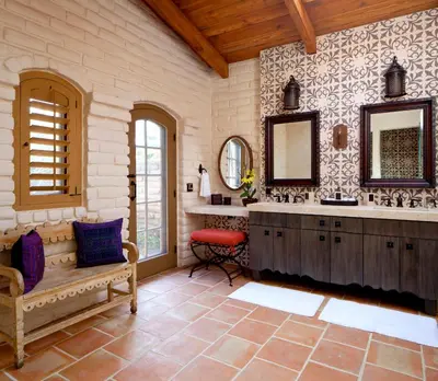 a bathroom with a sink and two mirrors and a bench at Rancho Valencia Resort and Spa in Rancho Santa Fe