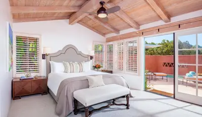 a bedroom with a large bed and a patio at Rancho Valencia Resort and Spa in Rancho Santa Fe