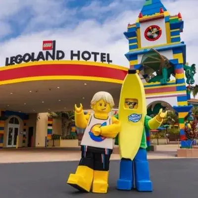 a statue of a man holding a banana in front of a hotel at LEGOLAND California Hotel and Castle Hotel in Carlsbad