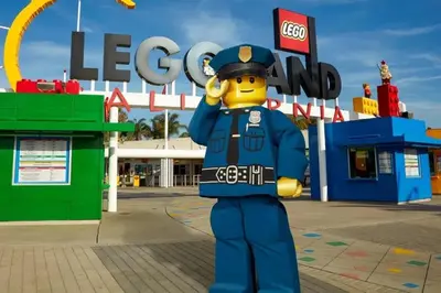 a person dressed in a fireman costume in front of a lego sign at LEGOLAND California Hotel and Castle Hotel in Carlsbad