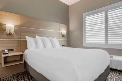 a large white bed in a hotel room with a window at Best Western Plus Lake Elsinore Inn & Suites in Lake Elsinore