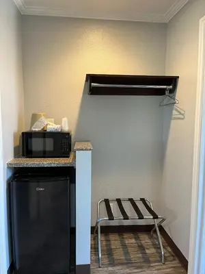 a kitchen with a microwave and a chair in a room at Laguna Inn and Suites in San Juan Capistrano