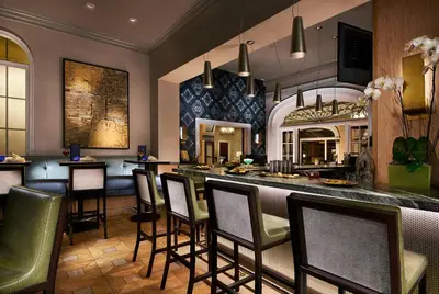a bar in a restaurant with chairs and a counter at Grande Colonial La Jolla in San Diego