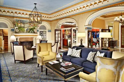 a living room with a blue couch and chairs at Grande Colonial La Jolla in San Diego
