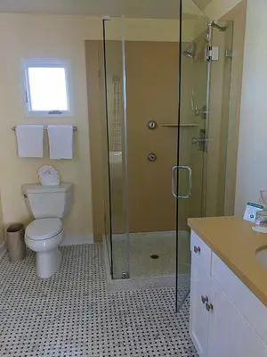 a bathroom with a toilet and a glass shower at Grande Colonial La Jolla in San Diego