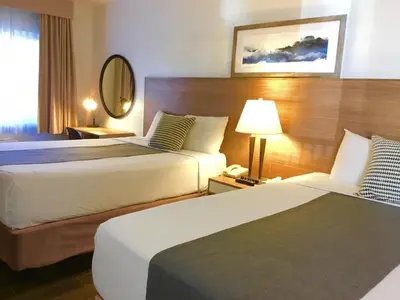 a hotel room with two beds and a mirror at Downtown San Diego Lodge in San Diego