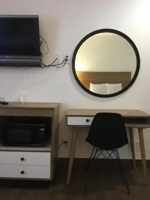 a mirror on a wall with a desk and a chair at Downtown San Diego Lodge in San Diego