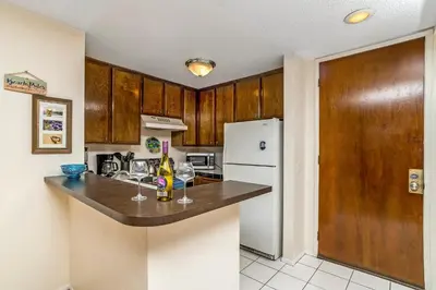 a kitchen with a counter and a refrigerator at Condo in Beachfront Resort B-212 in Oceanside