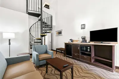 a living room with a couch and a flat screen tv at Best Western Plus Irvine Spectrum Hotel in Lake Forest