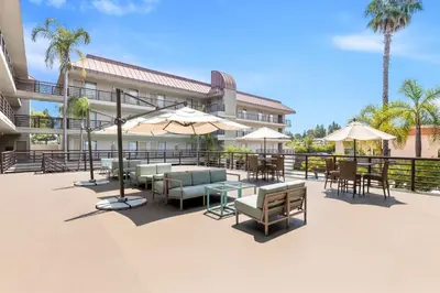 a patio with tables and chairs and umbrellas at Best Western Plus Irvine Spectrum Hotel in Lake Forest