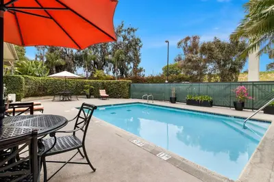 a swimming pool with a table and an umbrella at Best Western Chula Vista/Otay Valley Hotel in Chula Vista
