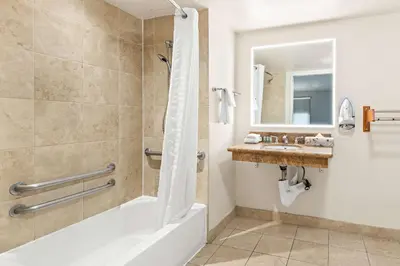 a bathroom with a tub shower and a sink at Best Western Chula Vista/Otay Valley Hotel in Chula Vista