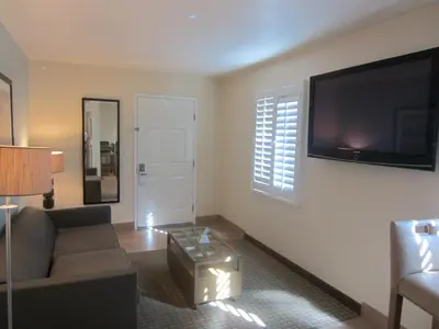 a living room with a couch and a flat screen tv at PB Surf Beachside Inn in San Diego