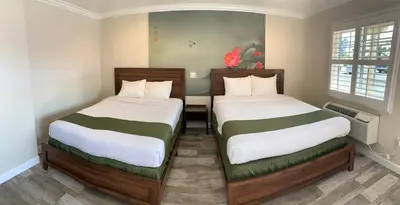 two beds in a small room with sidx sidx sidx sidx at Escondido Inn in Escondido