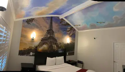a bedroom with a mural of the eiffel tower at Escondido Inn in Escondido