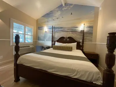 a bedroom with a bed with a painting on the wall at Escondido Inn in Escondido