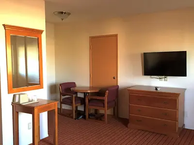 a hotel room with a small table and a television at Harvey's Motel SDSU La Mesa San Diego in San Diego
