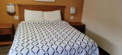 a bed in a hotel room with two night stands at Harvey's Motel SDSU La Mesa San Diego in San Diego