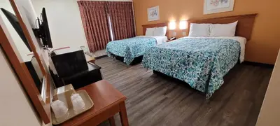 a hotel room with two beds and a table at Harvey's Motel SDSU La Mesa San Diego in San Diego