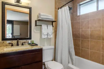 a bathroom with a toilet and a sink and a shower at Carlton Oaks Lodge, an Ascend Collection Hotel in Santee