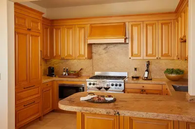a kitchen with wooden cabinets and a counter top at The Resort at Pelican Hill in Crystal Cove