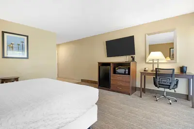 a hotel room with a bed and a desk and a television at Best Western Oceanside Inn in Oceanside