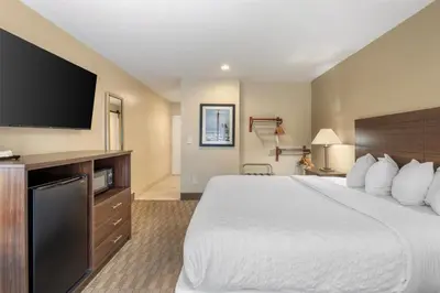 a hotel room with a large bed and a flat screen tv at Best Western Oceanside Inn in Oceanside