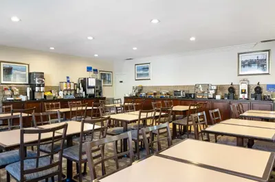 a dining room with tables and chairs and a bar at Best Western Oceanside Inn in Oceanside