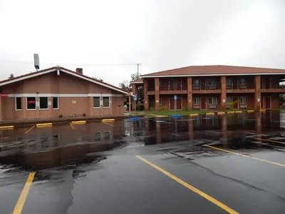 a wet parking lot in front of a building at Rancho California Inn Temecula in Temecula