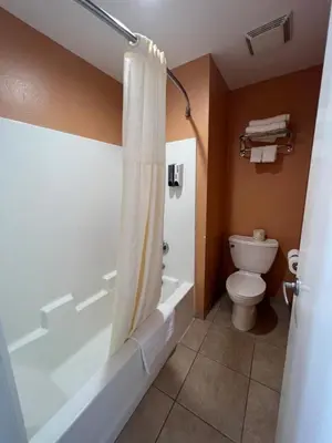 a bathroom with a tub and a toilet and a shower at Rancho California Inn Temecula in Temecula