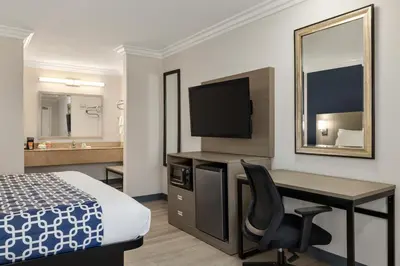 a hotel room with a desk and a bed and a mirror at Quality Inn Lake Elsinore I-15 in Lake Elsinore