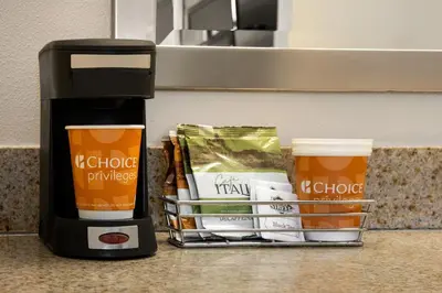 a coffee maker and cups on a counter with coffee at Quality Inn Lake Elsinore I-15 in Lake Elsinore