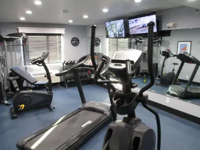 a gym with several cardio machines and a tv at Best Western Plus Diamond Valley Inn in Hemet