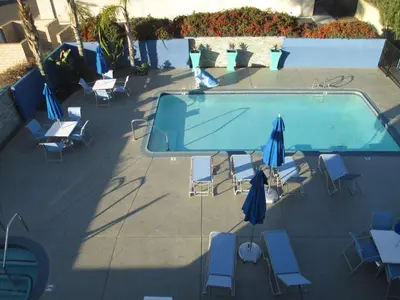an empty swimming pool with chairs and umbrellas at Best Western Plus Diamond Valley Inn in Hemet
