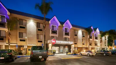 a hotel with cars parked in a parking lot at Best Western Plus Diamond Valley Inn in Hemet