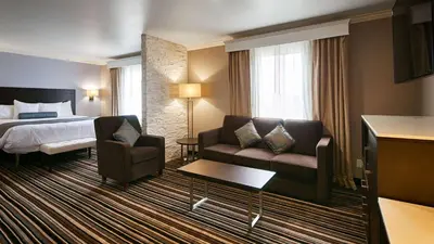 a hotel room with a bed and a couch at Best Western Plus Diamond Valley Inn in Hemet