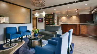a lobby with blue chairs and a couch and a table at Best Western Plus Diamond Valley Inn in Hemet