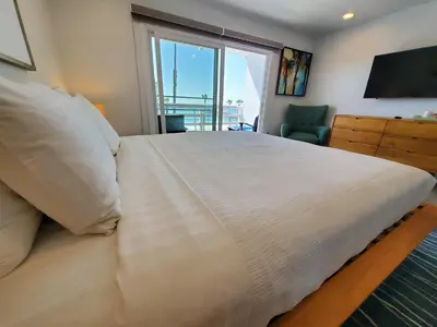 a bedroom with a large bed with a large window at Sea Horse Resort in San Clemente