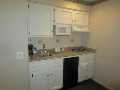 a kitchen with white cabinets and a sink at Old Town Inn in San Diego