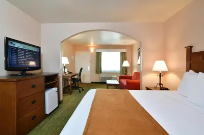 a hotel room with a bed and a television at Lamplighter Inn & Suites at SDSU in San Diego