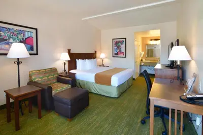 a hotel room with a bed and a desk at Lamplighter Inn & Suites at SDSU in San Diego