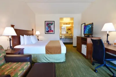 a hotel room with a bed and a desk at Lamplighter Inn & Suites at SDSU in San Diego