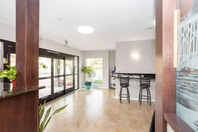 a hallway with a kitchen with a bar and stools at The Hotel Oceanside in Oceanside