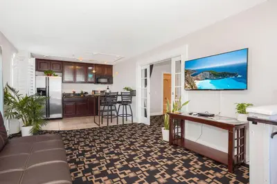 a living room with a couch and a kitchen at The Hotel Oceanside in Oceanside
