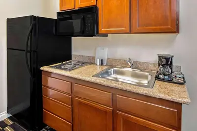a kitchen with a sink and a black refrigerator at The Hotel Oceanside in Oceanside