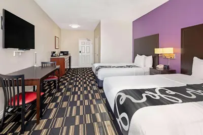 a hotel room with two beds and a desk at The Hotel Oceanside in Oceanside
