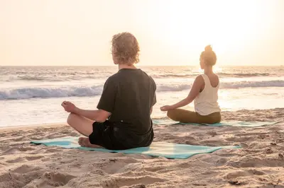 two people sitting on the beach watching the ocean at Laguna Surf Lodge by SCP Hotels in Laguna Beach