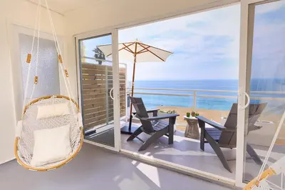 a porch with a hammock and a view of the ocean at Laguna Surf Lodge by SCP Hotels in Laguna Beach