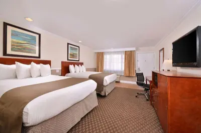 a hotel room with two beds and a flat screen tv at Best Western Capistrano Inn in San Juan Capistrano